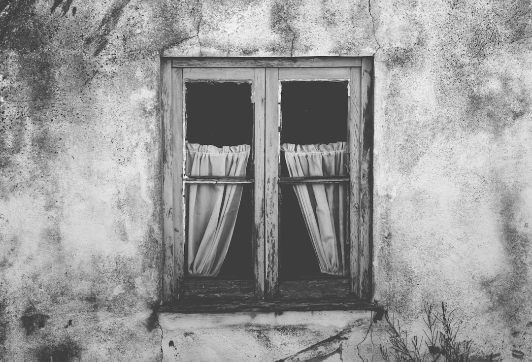 Black and white photography of an old window with curtains, in the center of Alologues village in Provence France –ar 128:87