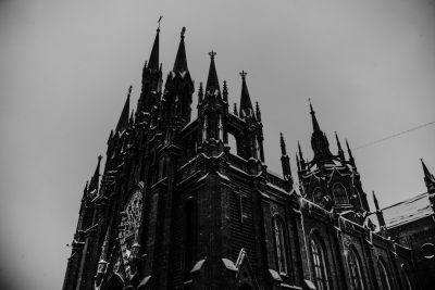 black and white photo of gothic cathedral, snow on roof, front view, black background, cinematic, shot with Sony Alpha A7 III, shot by Canon K35 Prime Lenses --ar 128:85