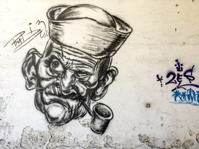 graffiti drawing of an old man with moustache and pipe wearing chef hat, on white wall --ar 4:3