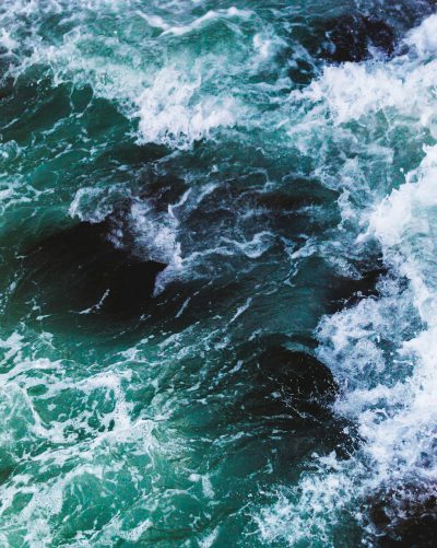 a top down view of the ocean with dark green and white waves, shot on film --ar 51:64