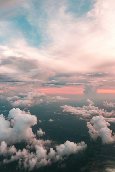 A photo of the sky from an airplane, with clouds in pink and blue hues, showing the horizon. A view over Saudi Arabia in the style of unsplash photography. --ar 85:128