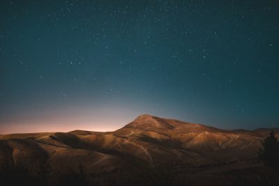 photograph of the night sky over desert hills, stars, landscape photography, unsplash style --ar 128:85