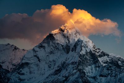 Close up of Ama Dabshit mountain in the Himalayas, golden hour lighting, snow covered peaks with dramatic clouds, captured in the style of Nikon d850. --ar 128:85