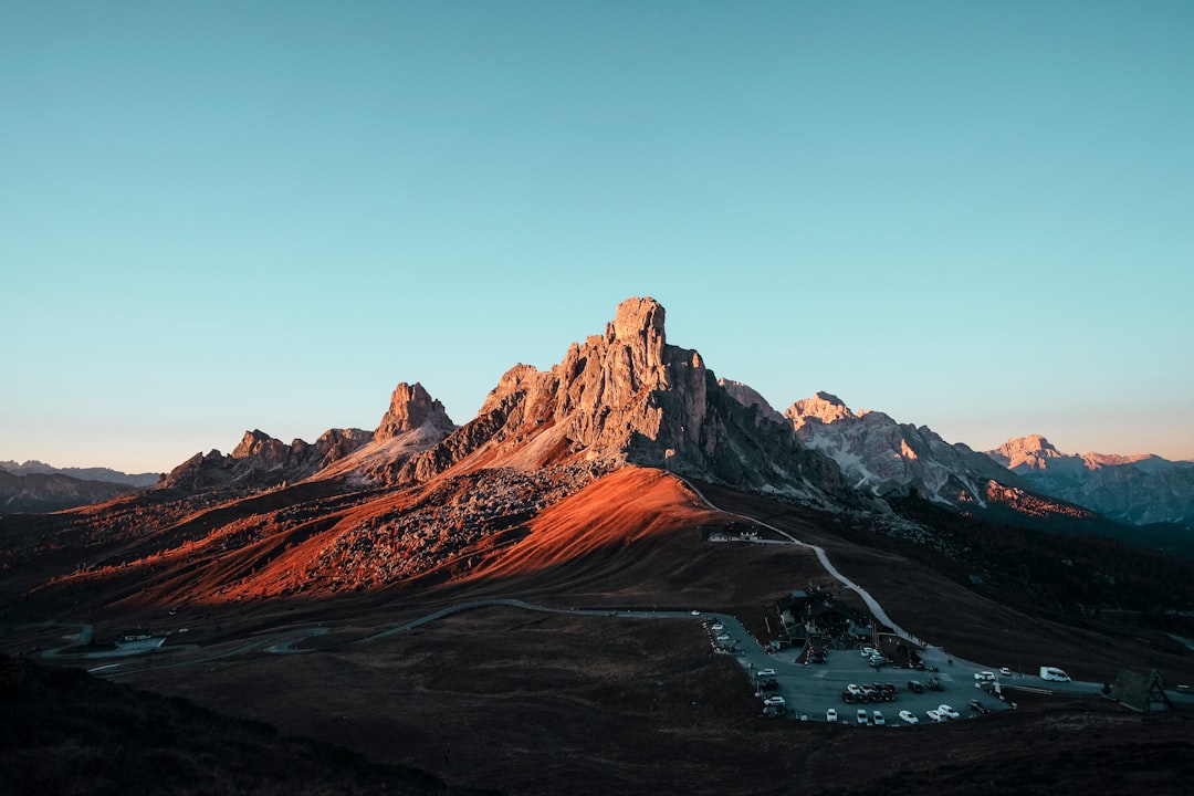 A mountain range in the Dolomites with a parking lot at sunset, DSLR photography, photo taken from above, in the style of Unsplash, panorama, Canon EOS R5 –ar 128:85