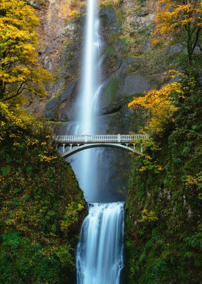 MMINO garments wallpaper, photograph of Multnomah Falls in Oregon, waterfall with white bridge in the middle, autumn colors, lush greenery, high resolution photography, in the style of Canon EOS R5 --ar 91:128