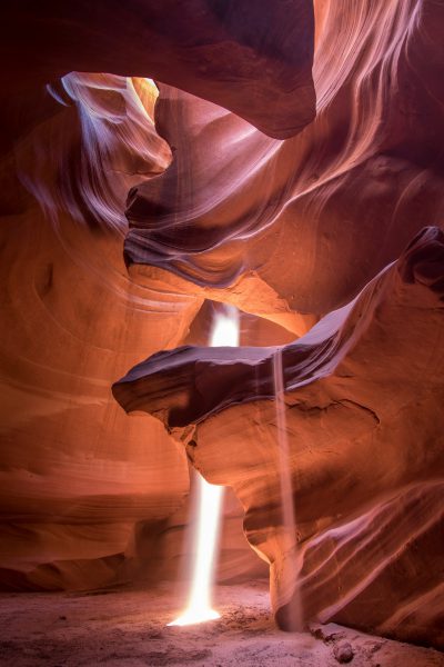 A beautiful award-winning photo of light streaming into Antelope Canyon in Arizona, with the sand swirling around it in the style of [Ansel Adams](https://goo.gl/search?artist%20Ansel%20Adams). --ar 85:128