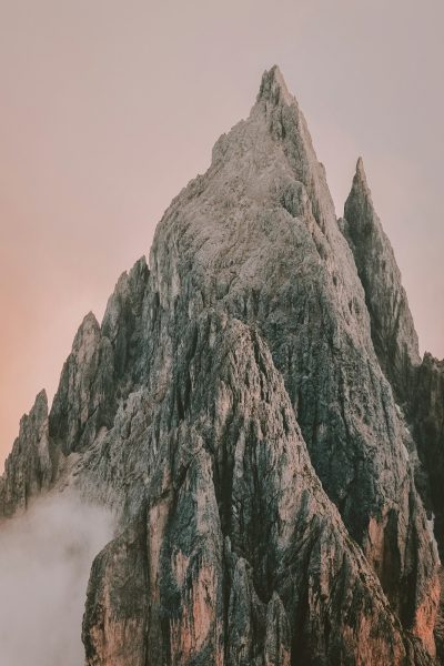 photography of the peak of the Dolomites in Italy, an epic shot, cinematic, during the golden hour, with a pink sky, moody, foggy, using natural light, hyper realistic, high resolution photography, photographed with a Sony Alpha A7 III and a macro lens, with very detailed --ar 85:128