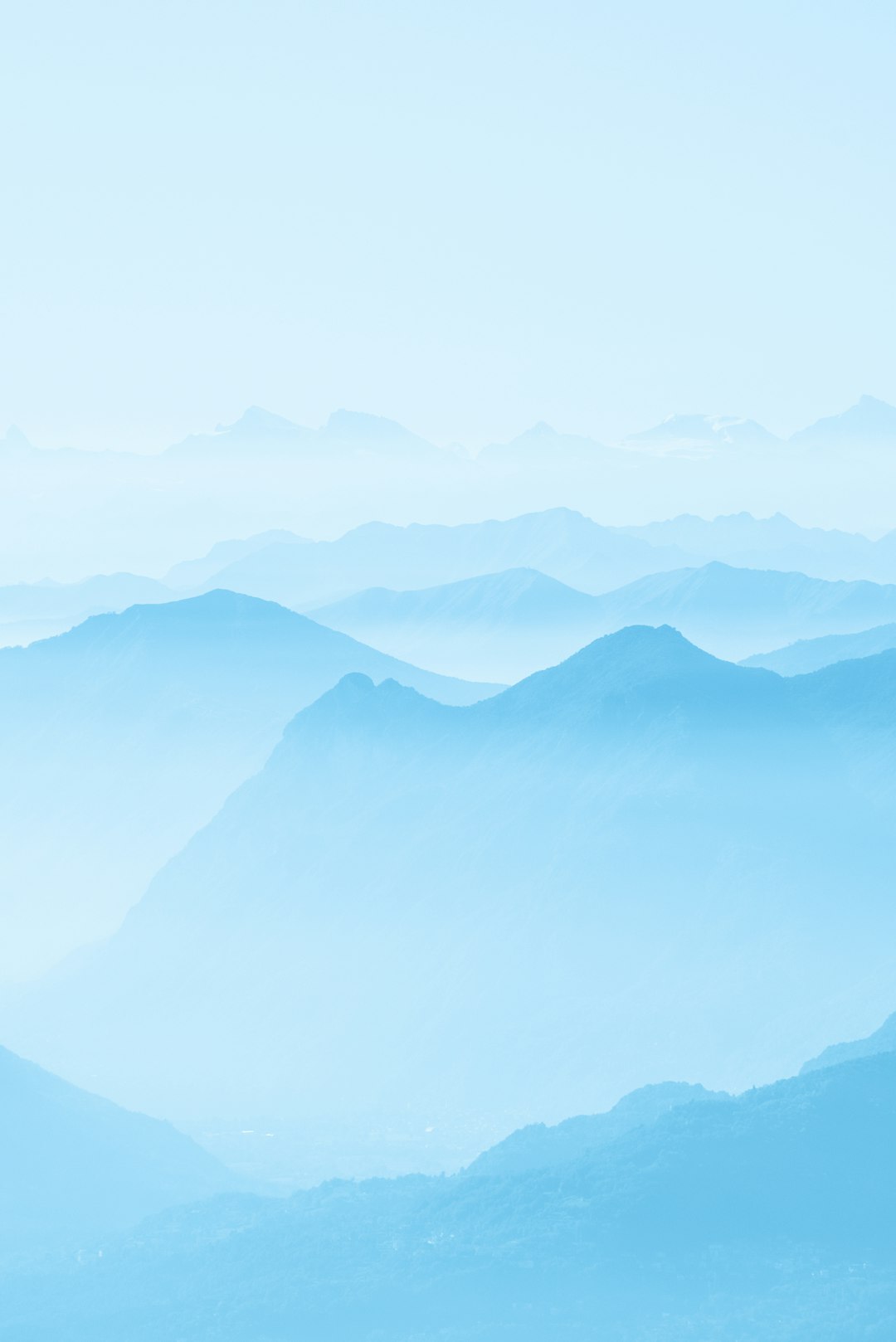 A light blue background with layers of mountains, creating an ethereal and dreamy atmosphere. The distant view showcases the vastness of nature, while the soft tones enhance tranquility. This photo was taken using a Canon EOS R5 mirrorless camera with a 24-70mm f/8 lens in the style of impressionist landscapes. –ar 85:128