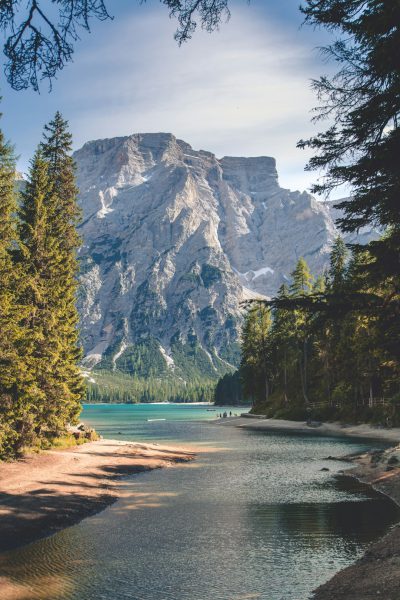 photograph of the dolomites with lake braies in italy, forest and beach --ar 85:128