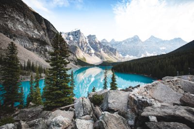 photograph of Moraine Lake in Canada, turquoise water surrounded by rocky mountains and pine trees, shot with Sony Alpha A7R IV mirrorless camera with Zeiss Batis lens, natural light, wide angle, hyper realistic --ar 128:85