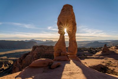 Delicate arch in Arches National Park, Utah with the sun shining through it at sunrise. The rock formation is one of many in Moab and highlights its unique beauty. , shot in the style of Sony Alpha A7R III. --ar 128:85