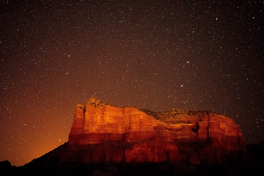 The red rocks of Sedona, Arizona at night with stars in the sky, beautiful, warm lighting. The photography is in the style of warm lighting. –ar 128:85