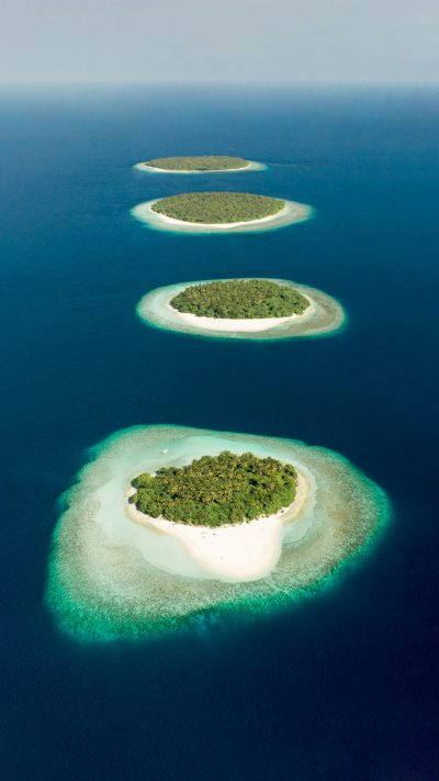 Aerial view of the group islands in Maldives, with lush greenery and pristine white sandy beaches. The turquoise waters create beautiful lagoons that reflect sunlight, creating a stunning scene from above. High resolution photography. This is an award winning photograph by National Geographic magazine. Shot on Canon K35 Prime lenses --ar 9:16