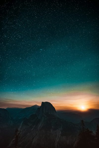 Photograph of the night sky over Yosemite with Half Dome in the distance, starry sky, sun setting, blue and orange tones, unsplash photography in the style of photography. --ar 85:128