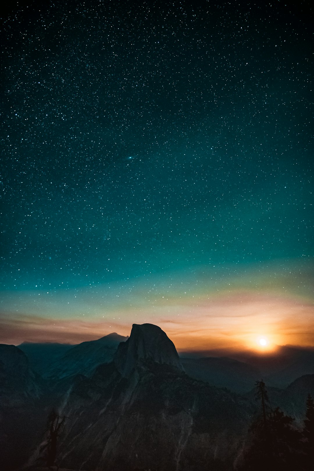 Photograph of the night sky over Yosemite with Half Dome in the distance, starry sky, sun setting, blue and orange tones, unsplash photography in the style of photography. –ar 85:128