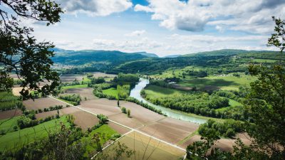 panoramic view of french countryside with fields and river, landscape photography, unsplash style, in the style of unsplash. --ar 16:9