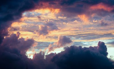 A photo of clouds taken from the sky at sunset, with dramatic lighting and colors, shot on film in the style of [Ansel Adams](https://goo.gl/search?artist%20Ansel%20Adams). --ar 128:77