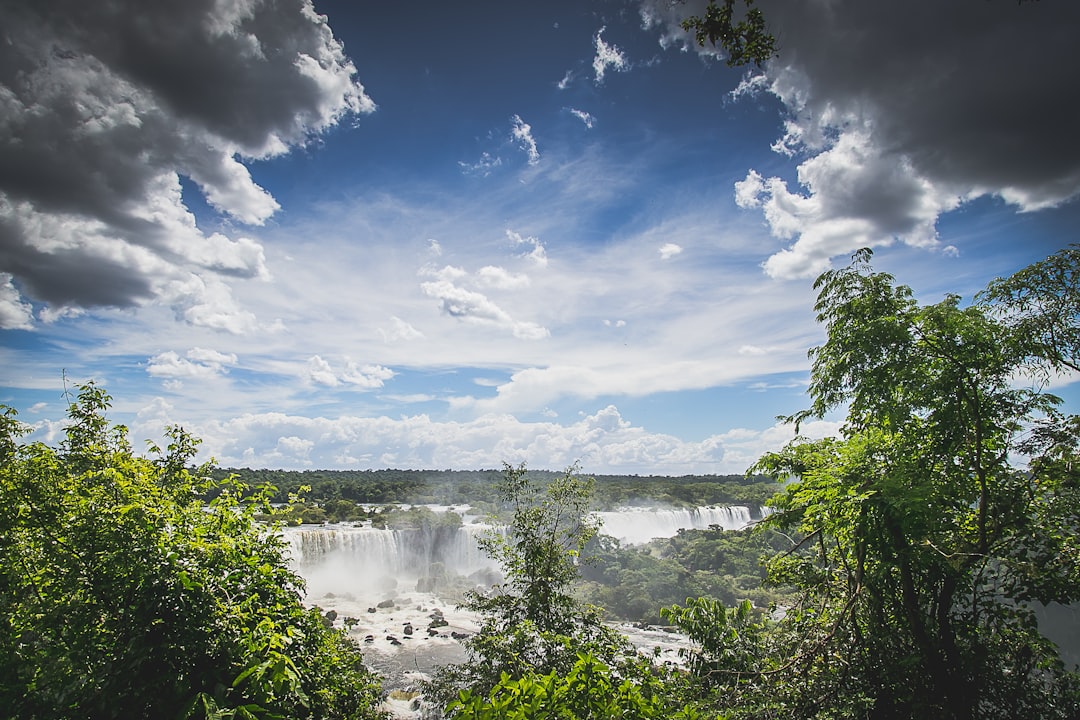 IguSVG style photo of Iguazu Falls from the top, beautiful clouds and sky, trees, shot in the style of Sony Alpha A7 III. –ar 128:85