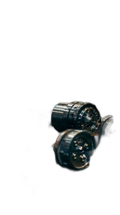 Closeup of two small metallic gears on a solid black background with soft lighting and a centered composition in the minimalist photography style typical of macro lens photographs. Reflections are visible on the surface of each gear as they contrast between light and dark areas. The focus is sharp with no blur in the center, creating a mysterious and intriguing mood.